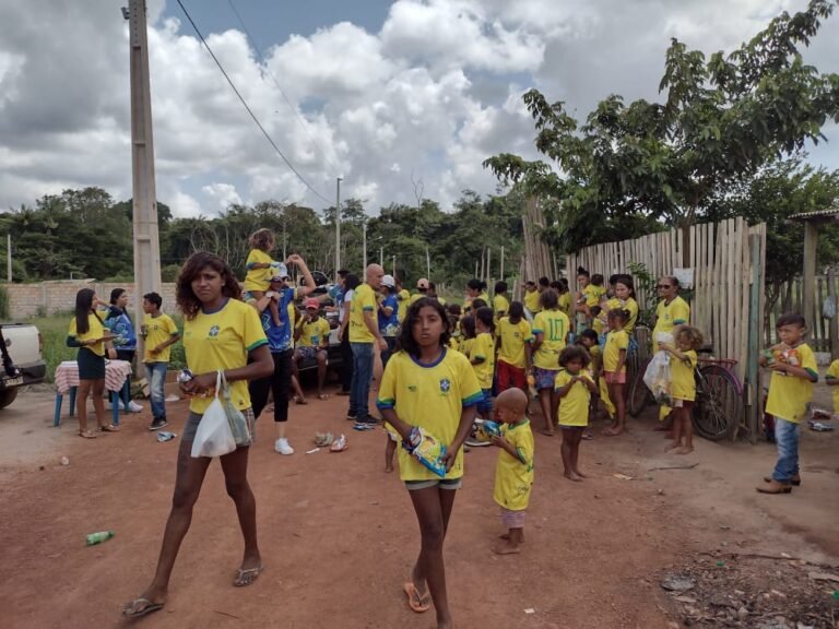 Voluntários distribuem camisas da seleção brasileira para crianças carentes
